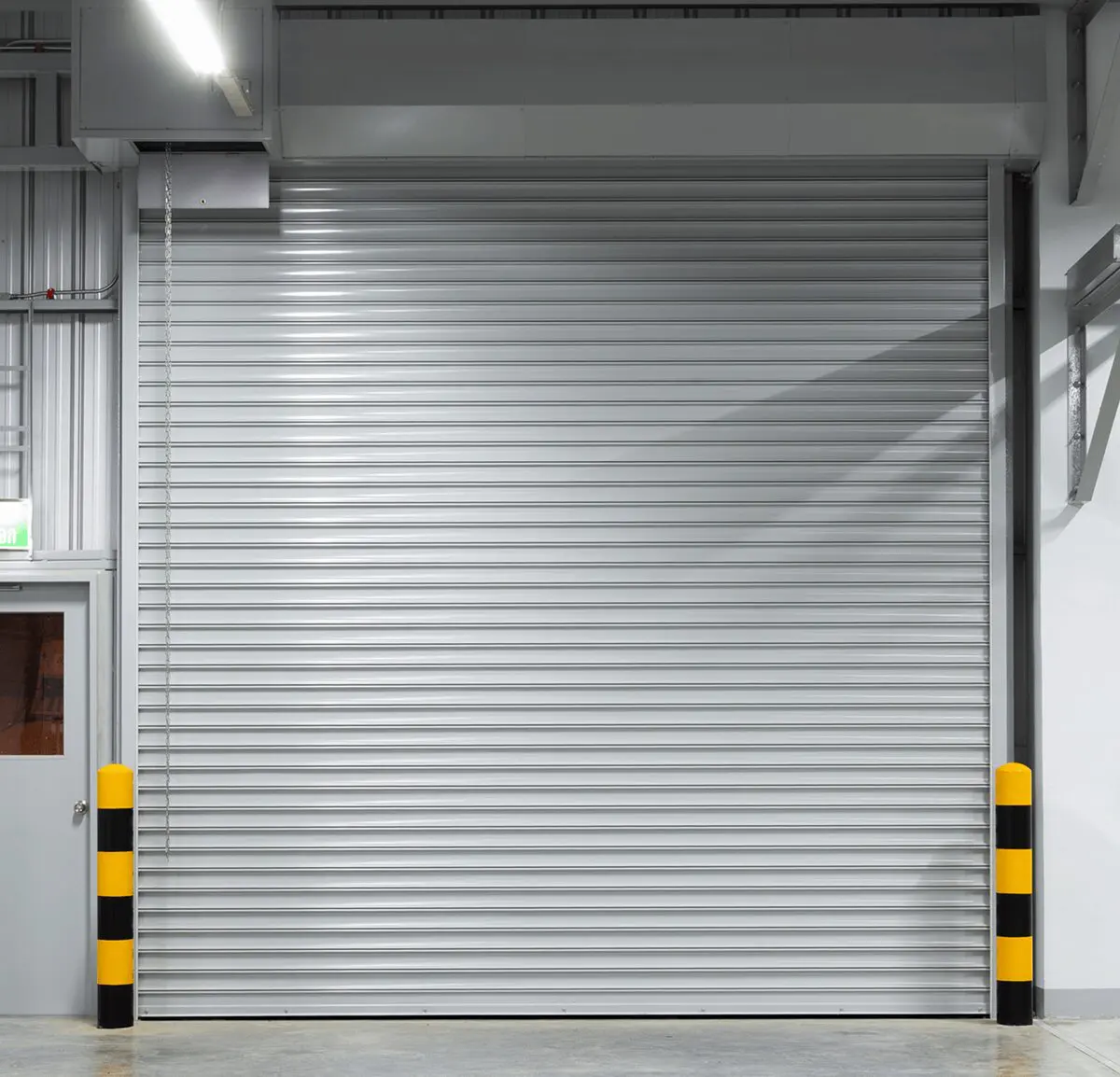 Closed garage door with striped bollards